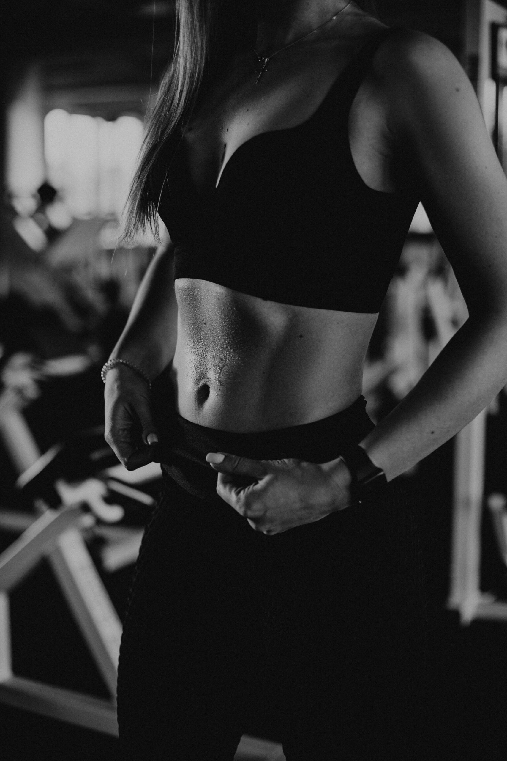 Artistic black and white photo of a woman in a sports bra showing dedication to fitness.